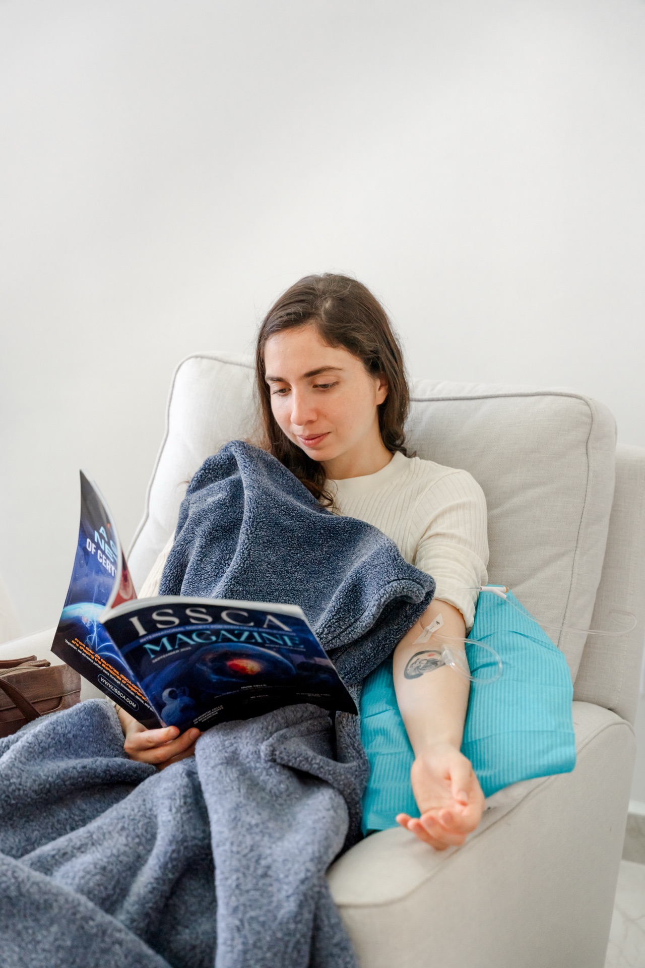 Patient reading a magazine while receiving IV therapy at the Regeneris clinic